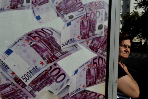 A woman stands a a bus station advertisinfg a lottery in Athens on September 19, 2012. Greece's finance minister said yesterday that Athens is close to sealing a deal with its international lenders on fresh austerity measures in exchange for billions of euros in aid funds. AFP PHOTO /LOUISA GOULIAMAKI        (Photo credit should read LOUISA GOULIAMAKI/AFP/Getty Images)